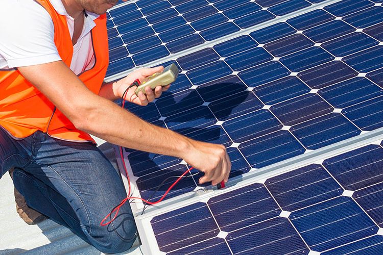 Mann überprüft eine Photovoltaik-Anlage