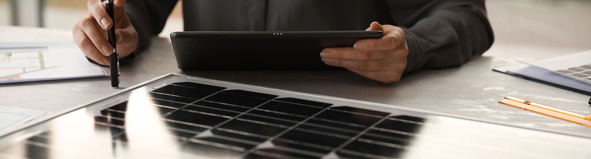 Mann mit Tablet plant eine Photovoltaik-Anlage